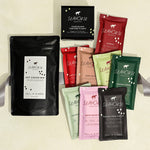 Collection of Seahorse chocolate products including hot cocoa mix and various chocolate bars and chocolate sampler on a light background.