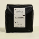 Black bag of Seahorse Hot Cocoa Mix on a beige background