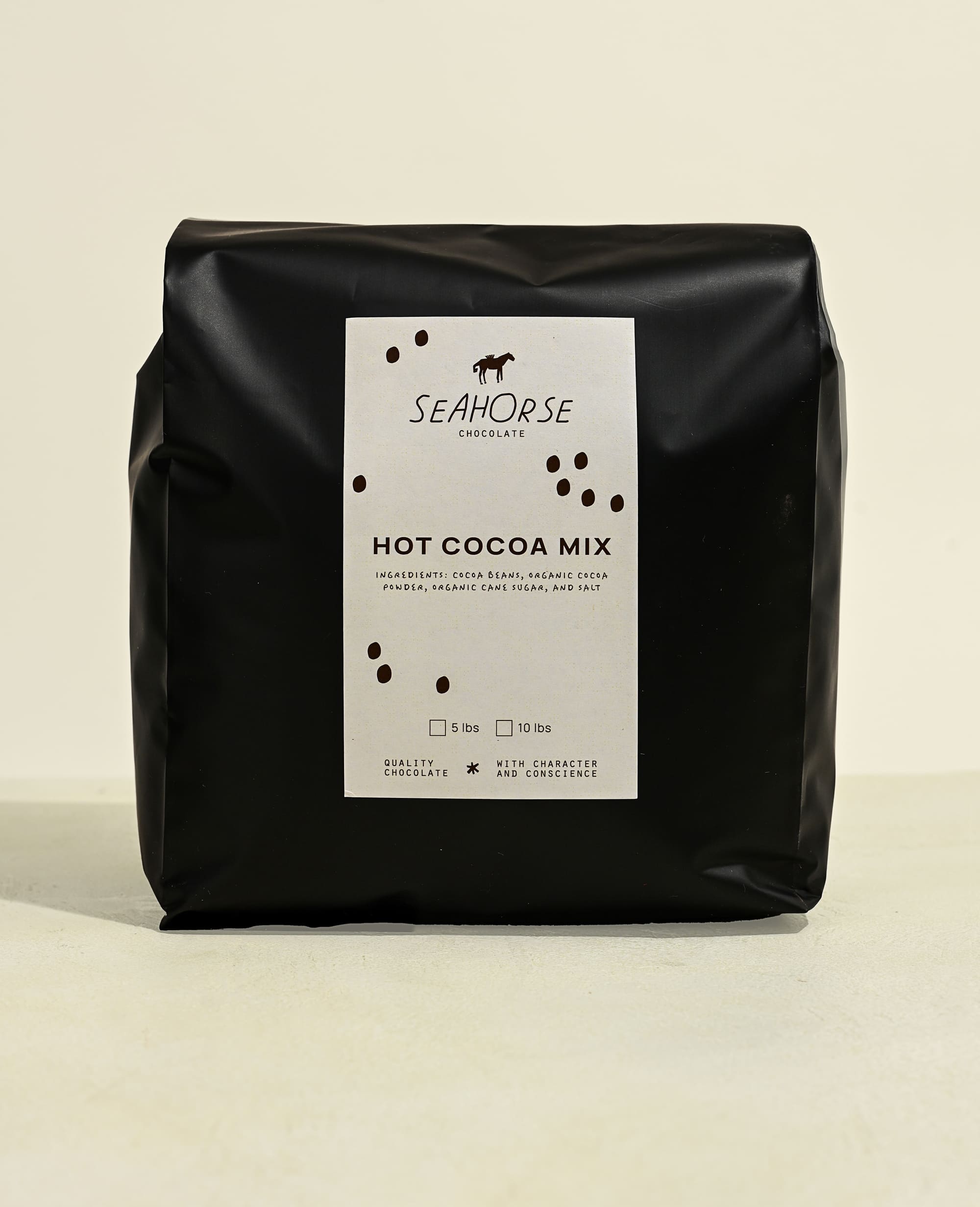 Black bag of Seahorse Hot Cocoa Mix on a beige background