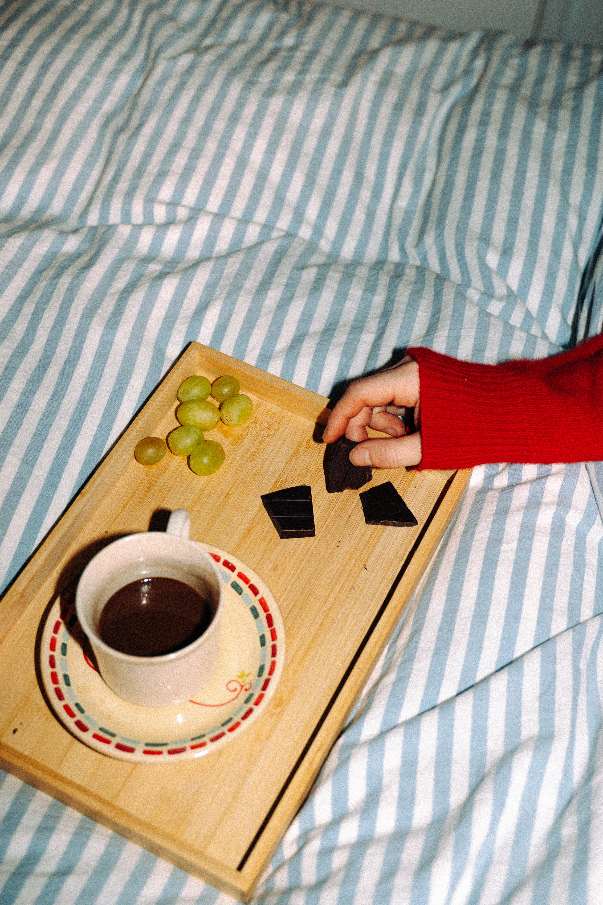 Tray with hot cocoa and Seahorse Chocolate bars on a striped bedspread